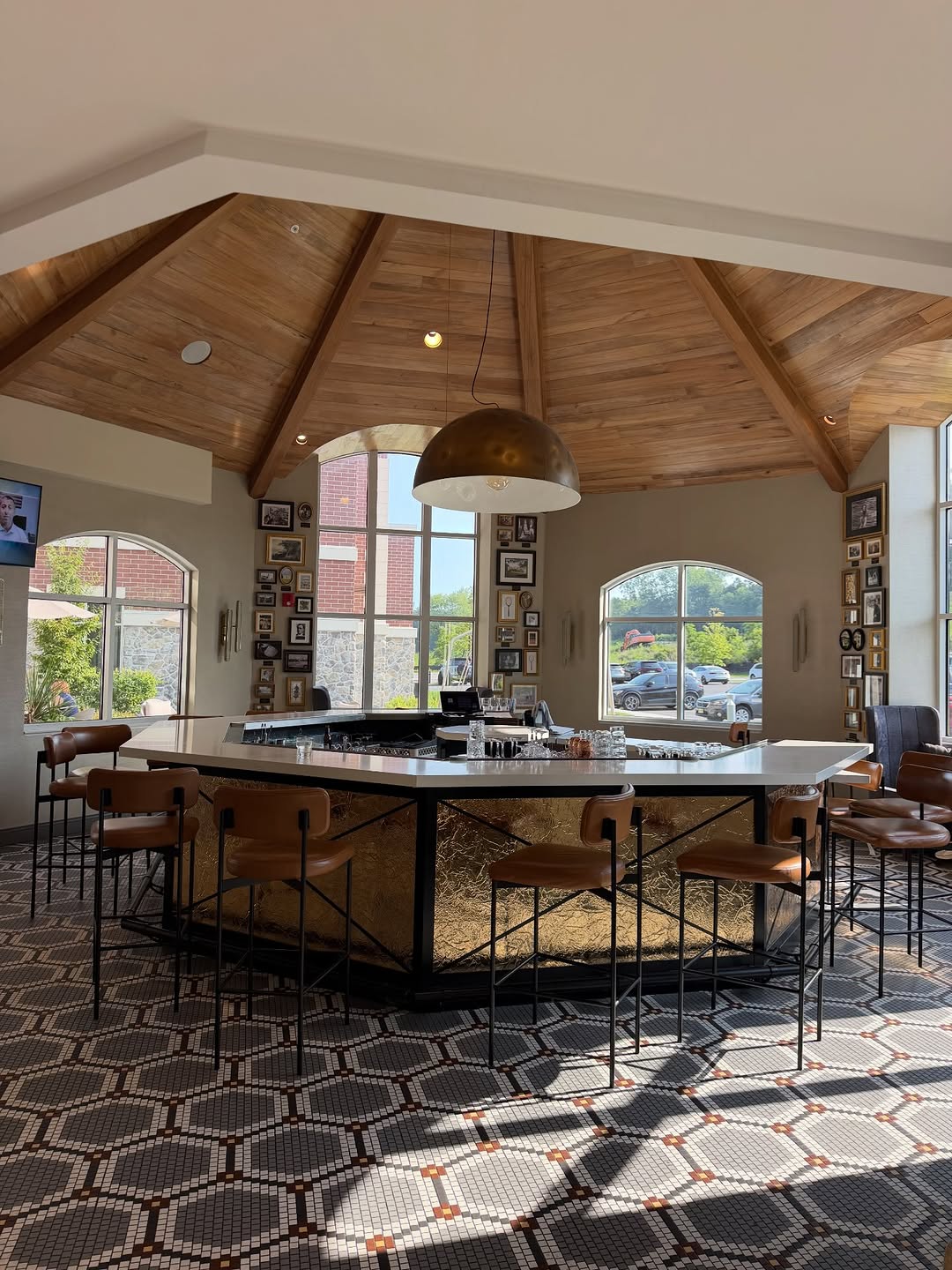 Stylish hotel bar with a gold-faced counter and vaulted wood ceiling